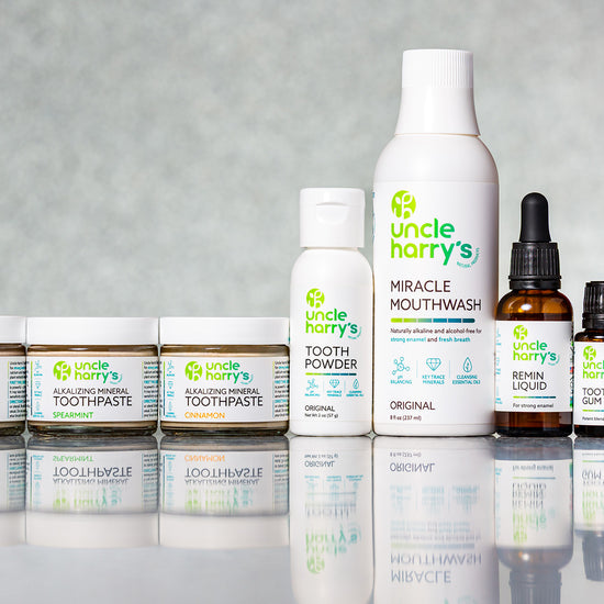 Collection of Uncle Harry's dental care products on a reflective surface with a gray background