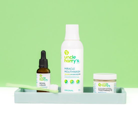 Collection of Uncle Harry's products including mouthwash, toothpaste, and remin liquid on a green background