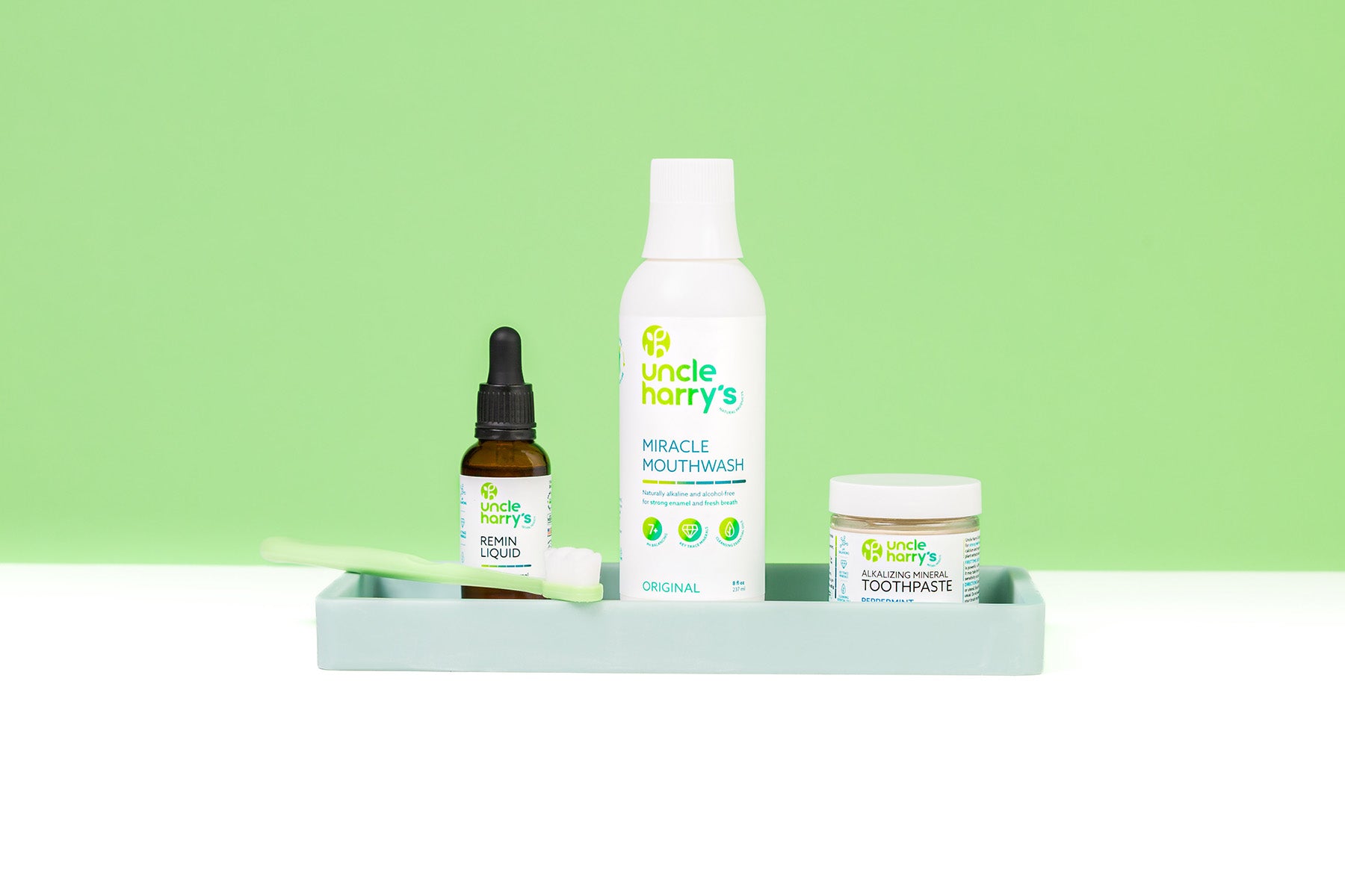 Collection of Uncle Harry's products including mouthwash, toothpaste, and remin liquid on a green background