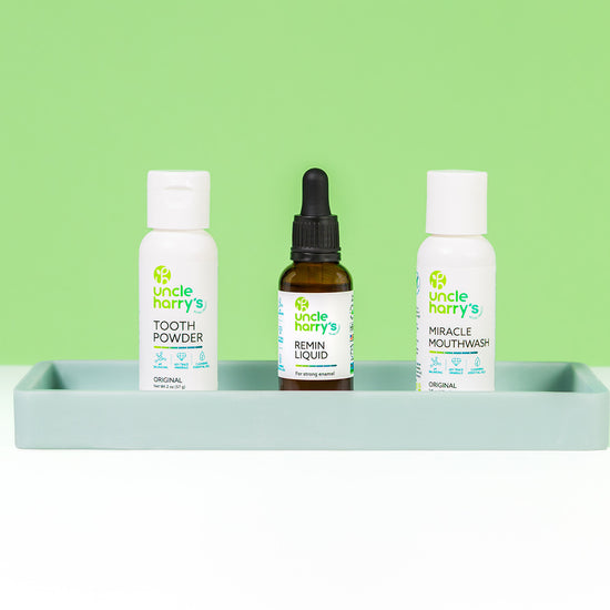 Uncle Harry's Tooth Powder, Remin Liquid, and Mouthwash on a gray tray with a green background