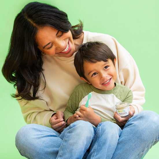 Woman and child sitting together on a green background
