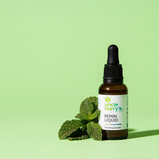 Bottle of Uncle Harry's Remin Liquid with mint leaves on a green background
