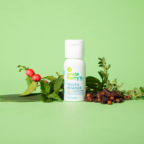 Uncle Harry's Tooth Powder bottle with natural ingredients on a green background