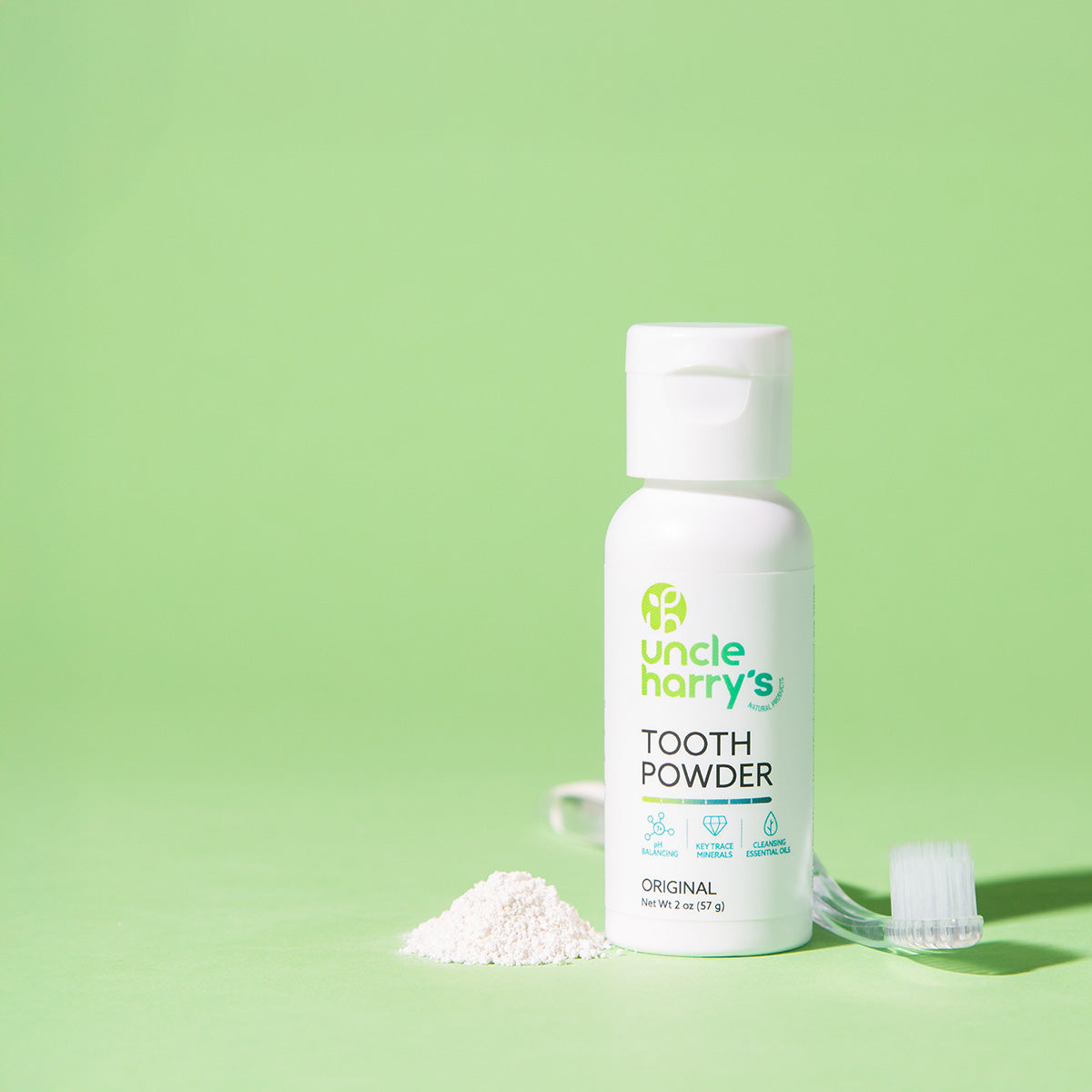 Uncle Harry's Tooth Powder bottle with toothbrush on a green background